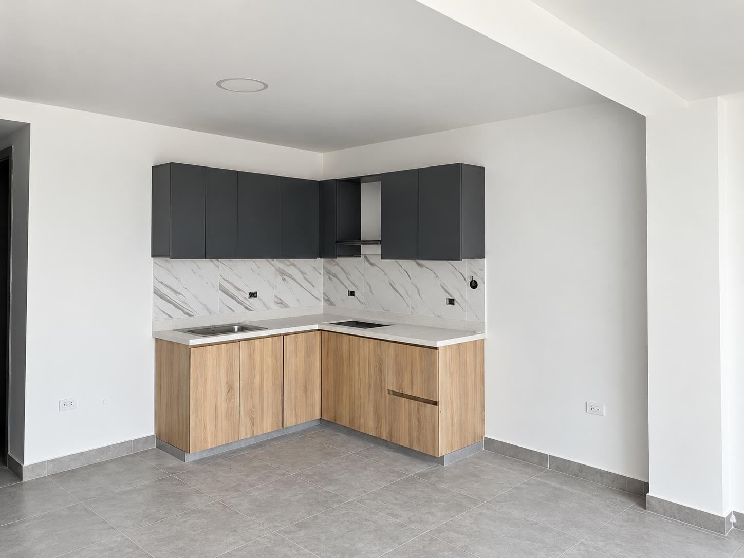 Cocina de un proyecto real de apartamentos, con acabados madera y carbón; fotografía retocada